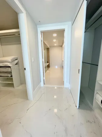 a view of a hallway with wooden floor and a livingroom