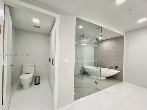 a bathroom with a toilet a sink and shower
