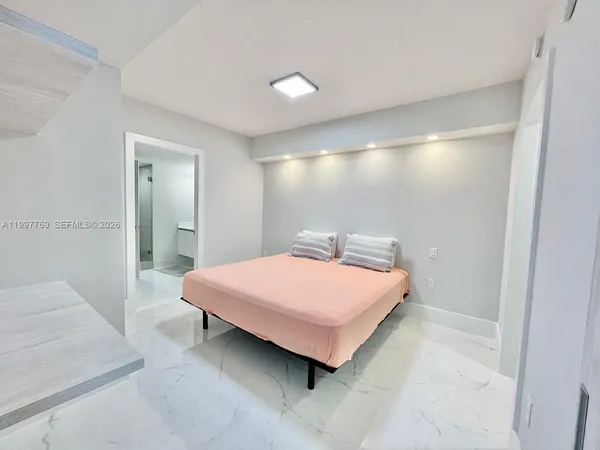 a bedroom with a bed and a mirror