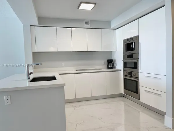 a kitchen with white cabinets and white appliances