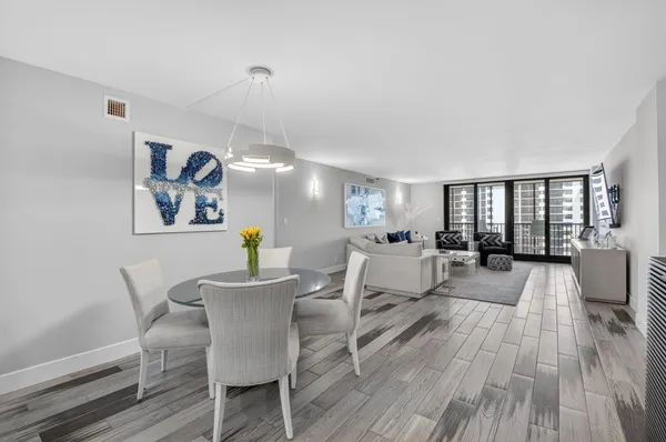 a living room with furniture a wooden floor and next to a window