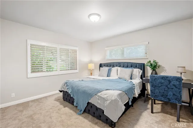 a spacious bedroom with a bed and chair