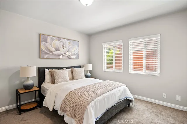 a bedroom with a bed and a painting on the wall