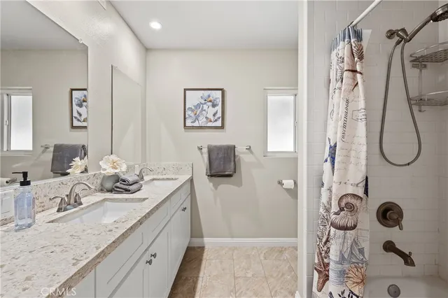 a bathroom with a granite countertop sink a mirror and shower