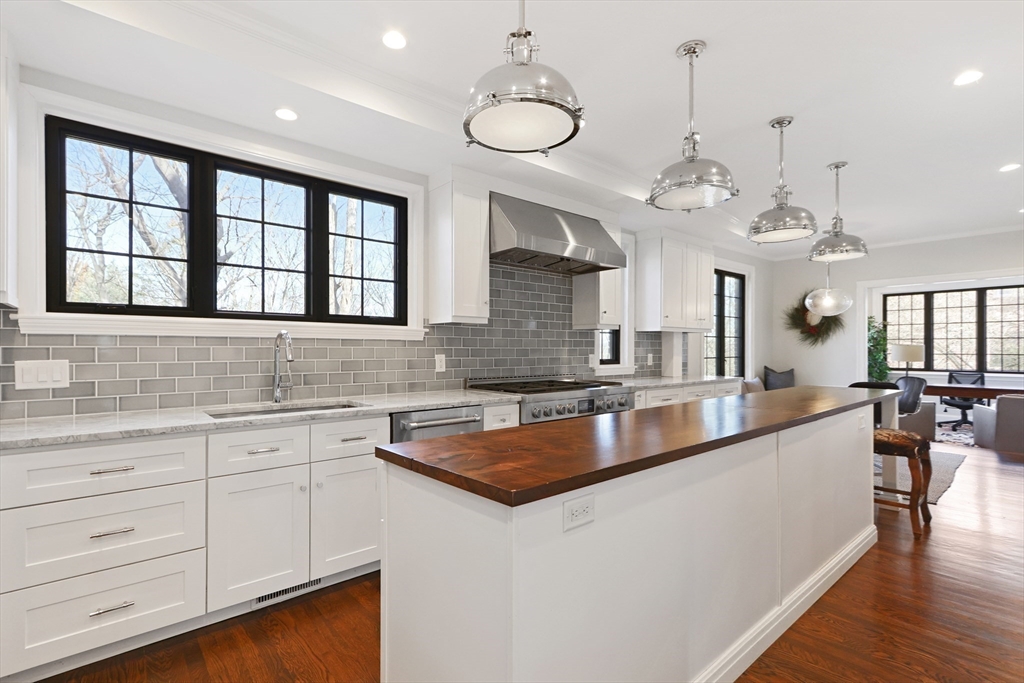 26 Greylock Road Newton, MA 02465 - Photo 6 of 28 a large kitchen with a large island in the center a sink a window and stainless steel appliances
