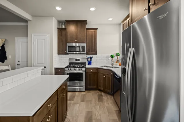 a kitchen with stainless steel appliances a refrigerator sink and stove