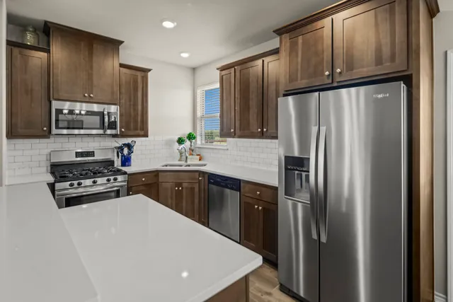 a kitchen with stainless steel appliances a refrigerator stove microwave and sink