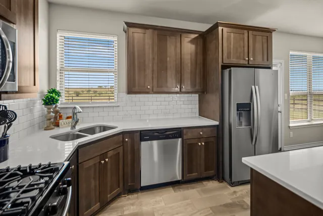 a kitchen with stainless steel appliances granite countertop a sink stove and refrigerator