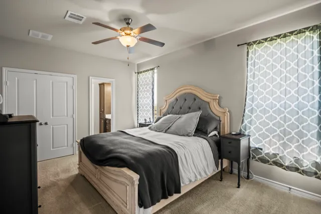 a bedroom with a bed and a ceiling fan