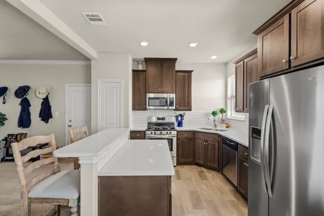 a kitchen with stainless steel appliances granite countertop a refrigerator sink and stove