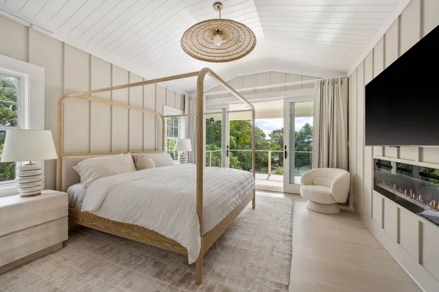 a spacious bedroom with a bed and a flat screen tv