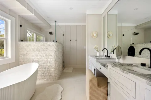 a bathroom with a granite countertop sink mirror and bathtub
