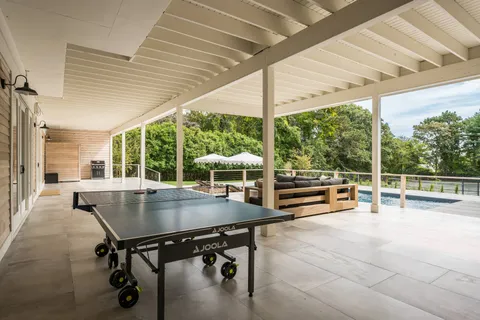 a view of a patio with a table chairs and a wooden deck