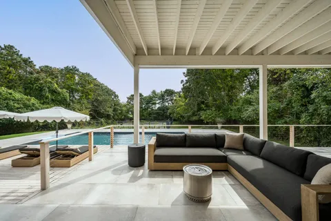 a view of roof deck with couches and potted plants