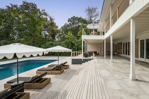 a view of a patio with couches table and chairs with wooden floor