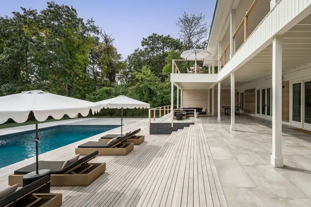 a view of a patio with couches table and chairs with wooden floor