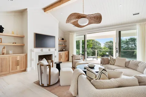 a living room with furniture a fireplace and a large window