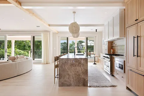 a living room with furniture large windows and flat screen tv