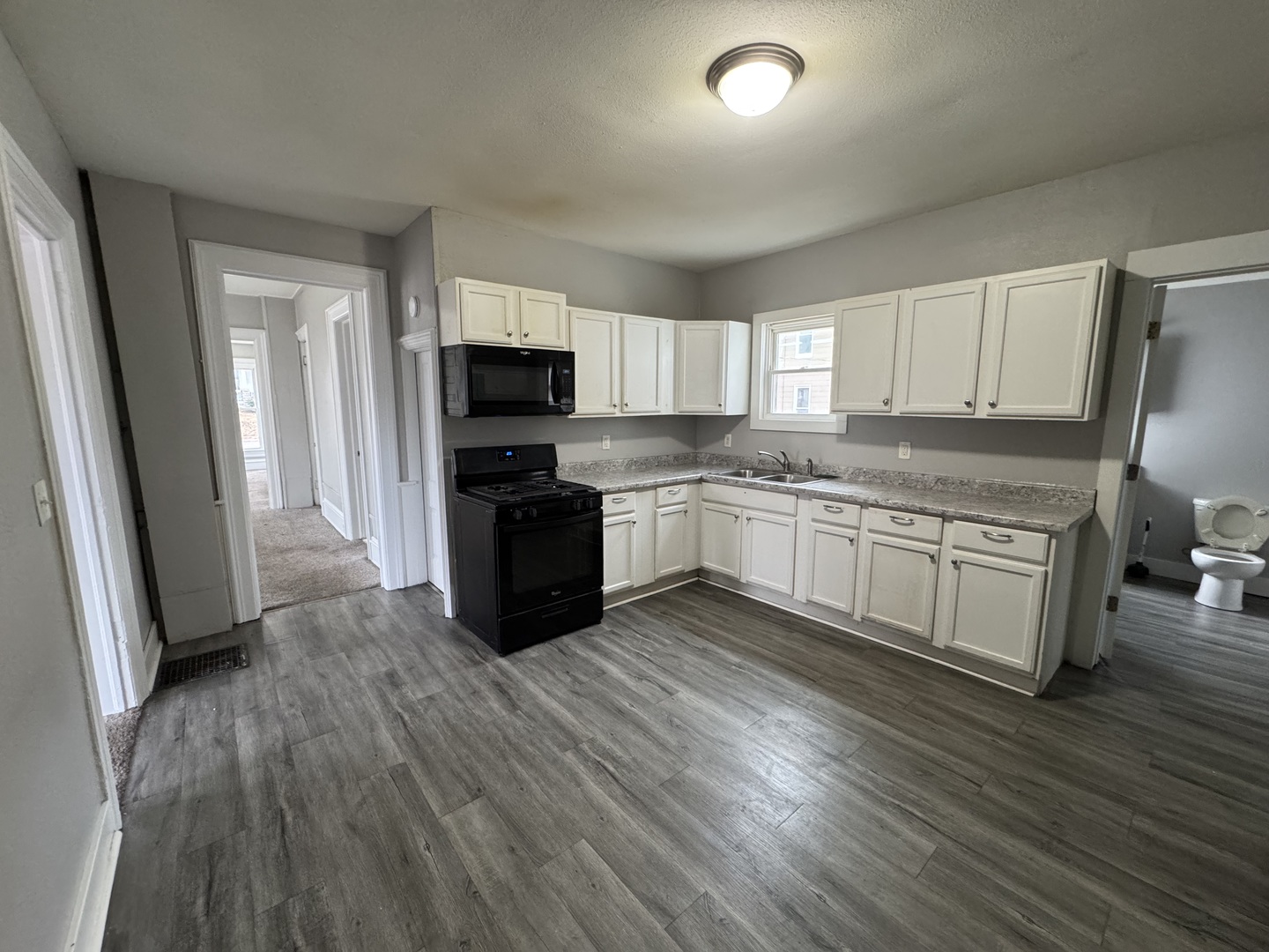 1155 12th Avenue Moline, IL 61265 - Photo 7 of 18 a kitchen with wooden floors and white appliances