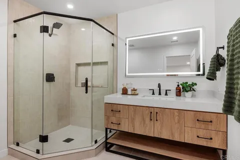 a bathroom with a shower sink and mirror