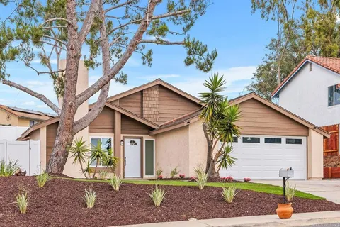 a front view of a house with a yard and potted plants