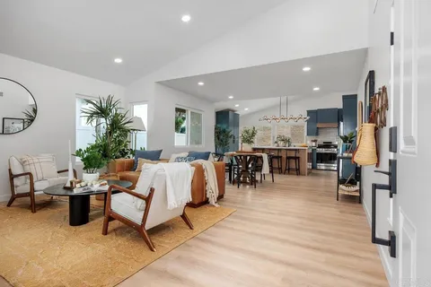 a living room with lots of furniture and kitchen view