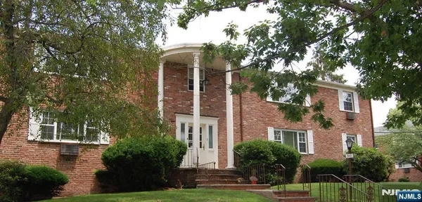 front view of a brick house with a yard