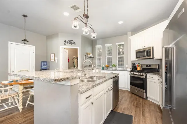 a kitchen with stainless steel appliances granite countertop a sink stove and refrigerator
