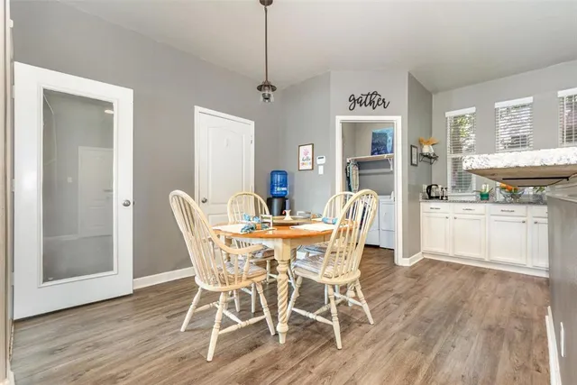 a dining room with furniture a chandelier and wooden floor