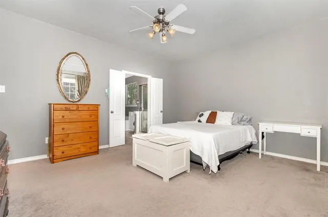 a bedroom with a bed a dresser and a chandelier