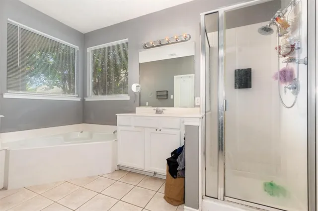 a bathroom with a tub a sink and a mirror