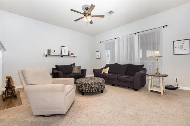 a living room with furniture and a ceiling fan