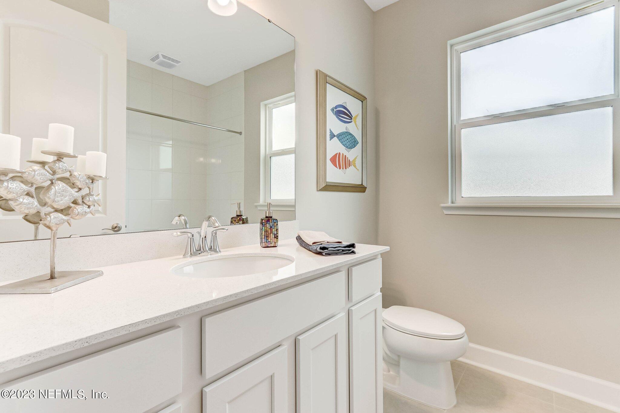 85156 Sandy Ridge Loop, Unit 18 Yulee, FL 32097 - Photo 21 of 25 a bathroom with a toilet sink and mirror