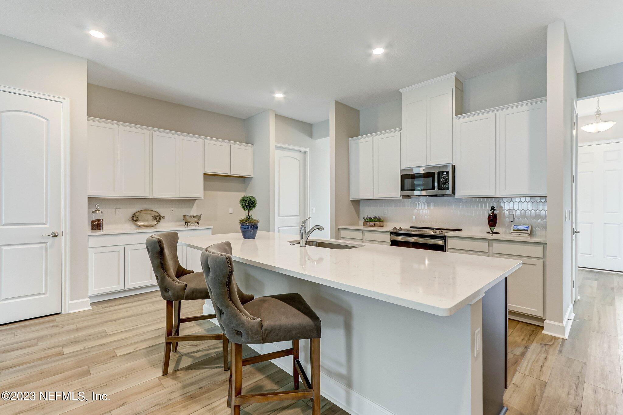 85156 Sandy Ridge Loop, Unit 18 Yulee, FL 32097 - Photo 10 of 25 a kitchen that has a lot of cabinets in it with appliances and wooden floor