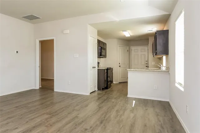a view of a kitchen with wooden floor and electronic appliances