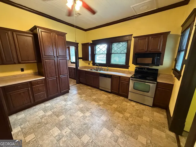 a kitchen with stainless steel appliances granite countertop a refrigerator and a stove top oven
