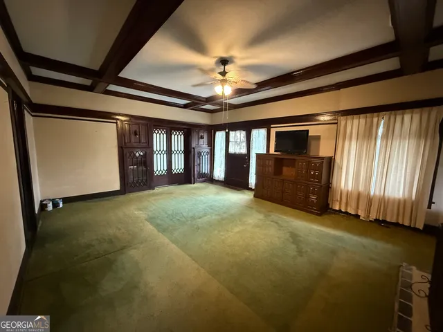 a view of an empty room with a fireplace and a window