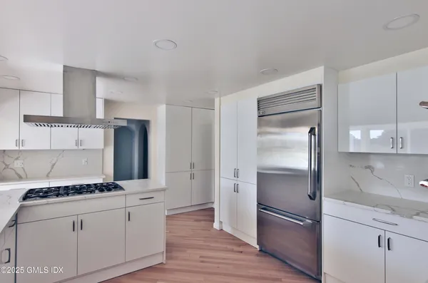 a kitchen with a refrigerator and a stove top oven