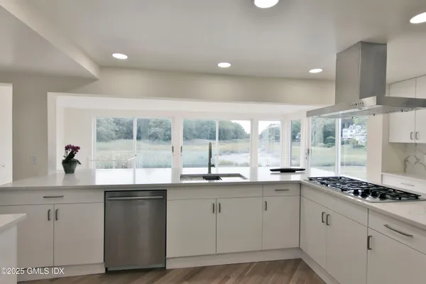 a kitchen with granite countertop a sink and white cabinets