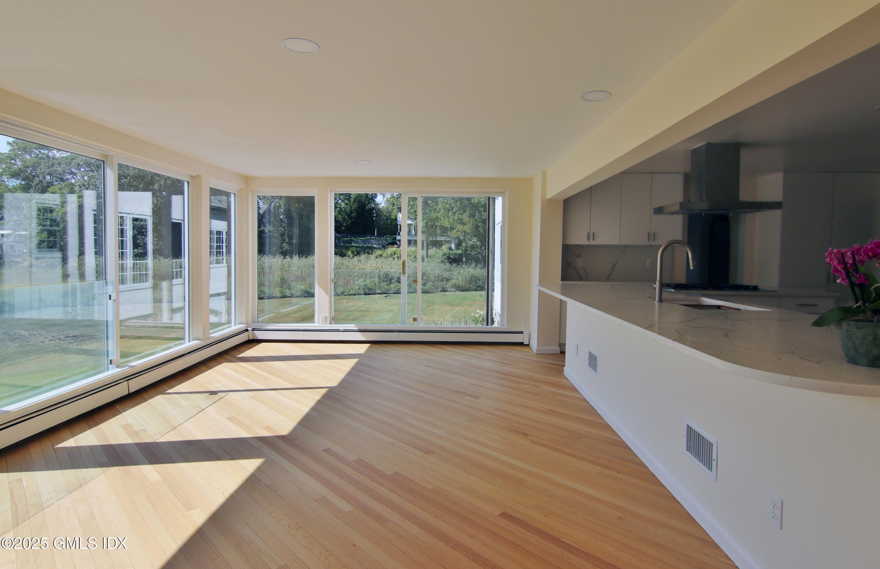 420 Davis Avenue Greenwich, CT 06830 - Photo 17 of 35 a large white kitchen with wooden floor and a large window
