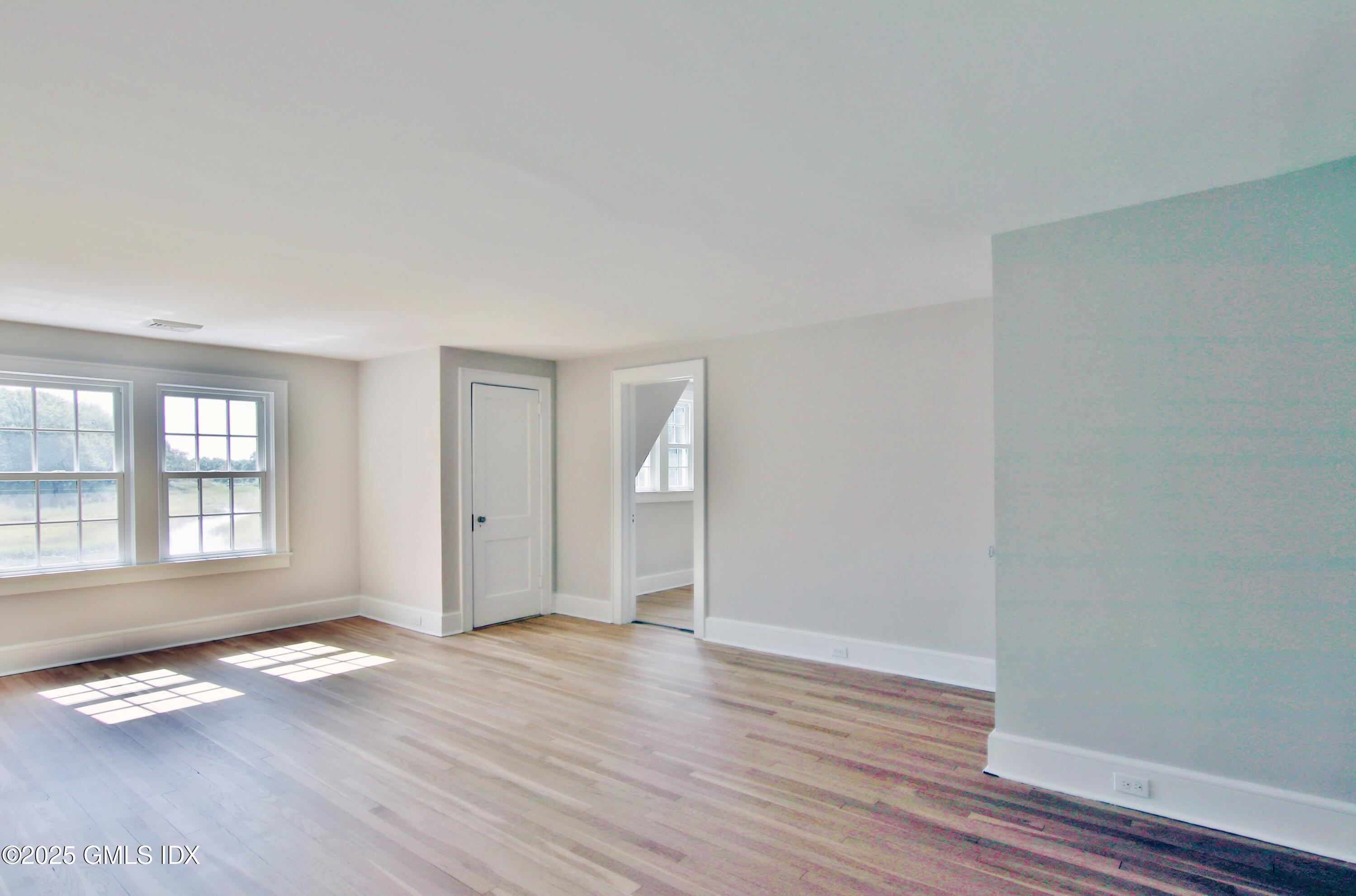 420 Davis Avenue Greenwich, CT 06830 - Photo 21 of 35 an empty room with wooden floor and windows