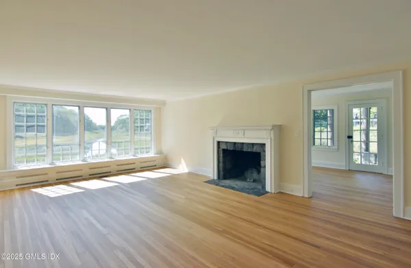 wooden floor fireplace and windows in an empty room