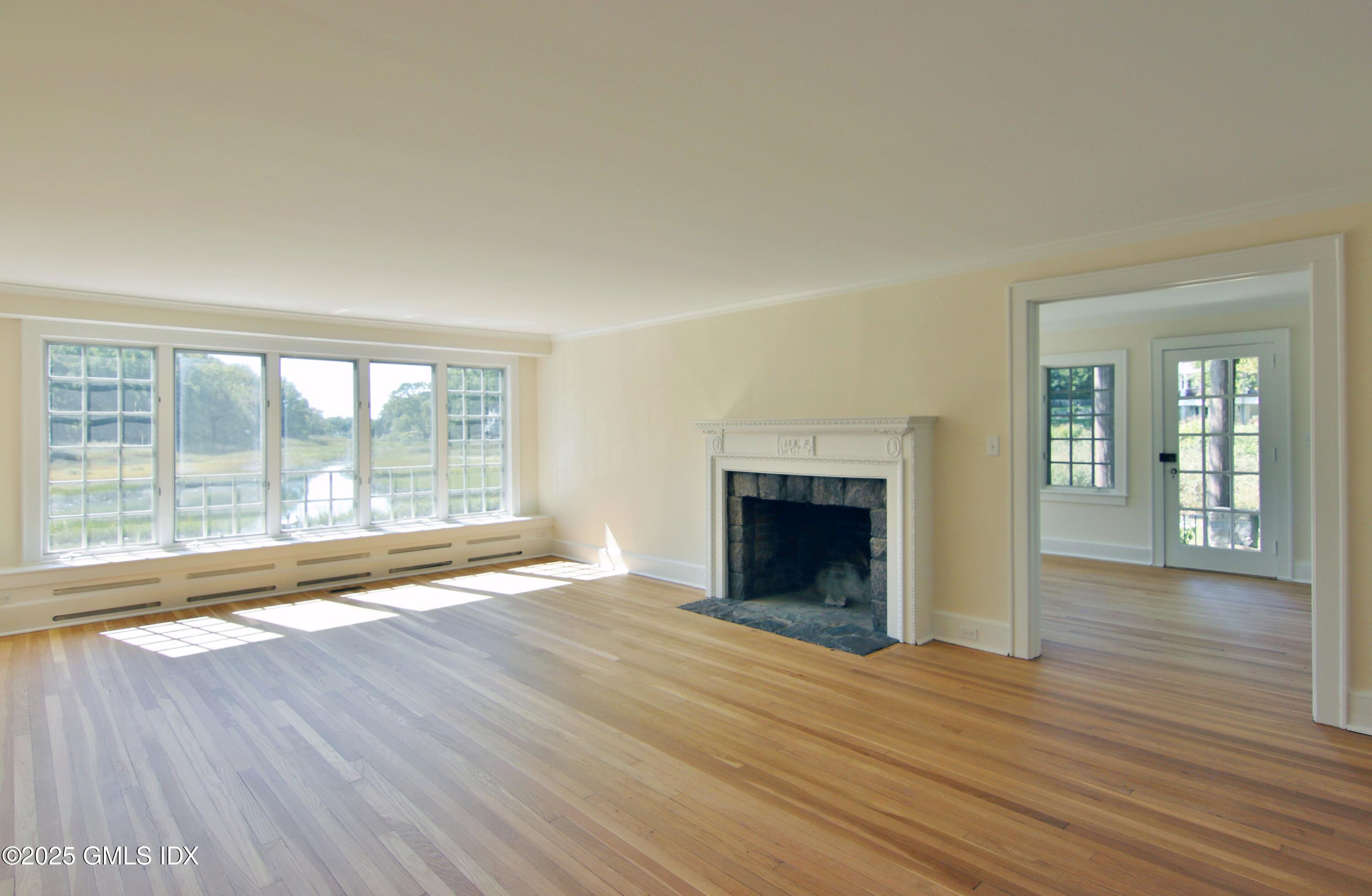 420 Davis Avenue Greenwich, CT 06830 - Photo 7 of 35 wooden floor fireplace and windows in an empty room