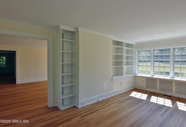 wooden floor in an empty room with a window