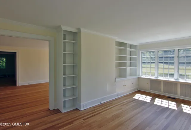 wooden floor in an empty room with a window
