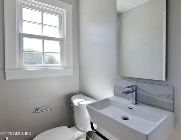 a bathroom with a sink mirror and toilet