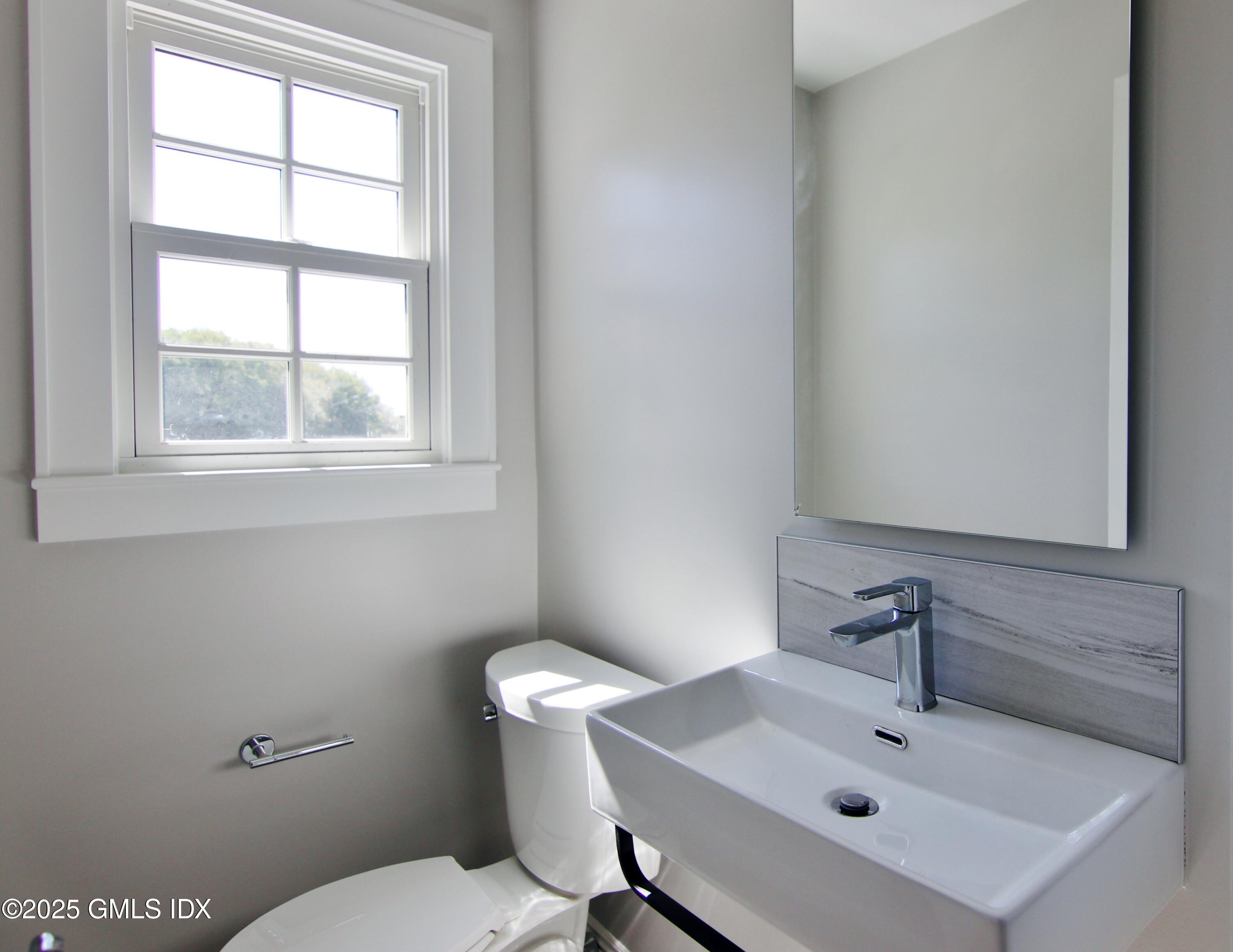 420 Davis Avenue Greenwich, CT 06830 - Photo 10 of 35 a bathroom with a sink mirror and toilet