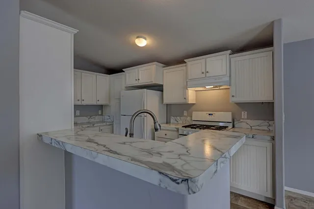 a kitchen with sink a stove and cabinets