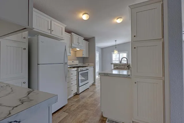 a kitchen with white cabinets and stainless steel appliances