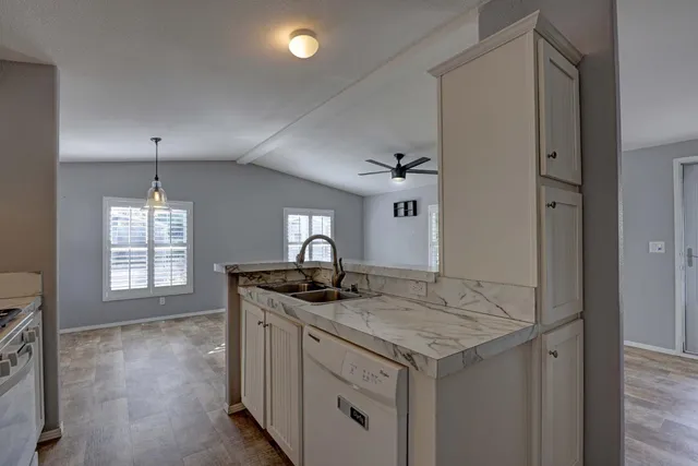 a kitchen with granite countertop a sink stove and cabinets